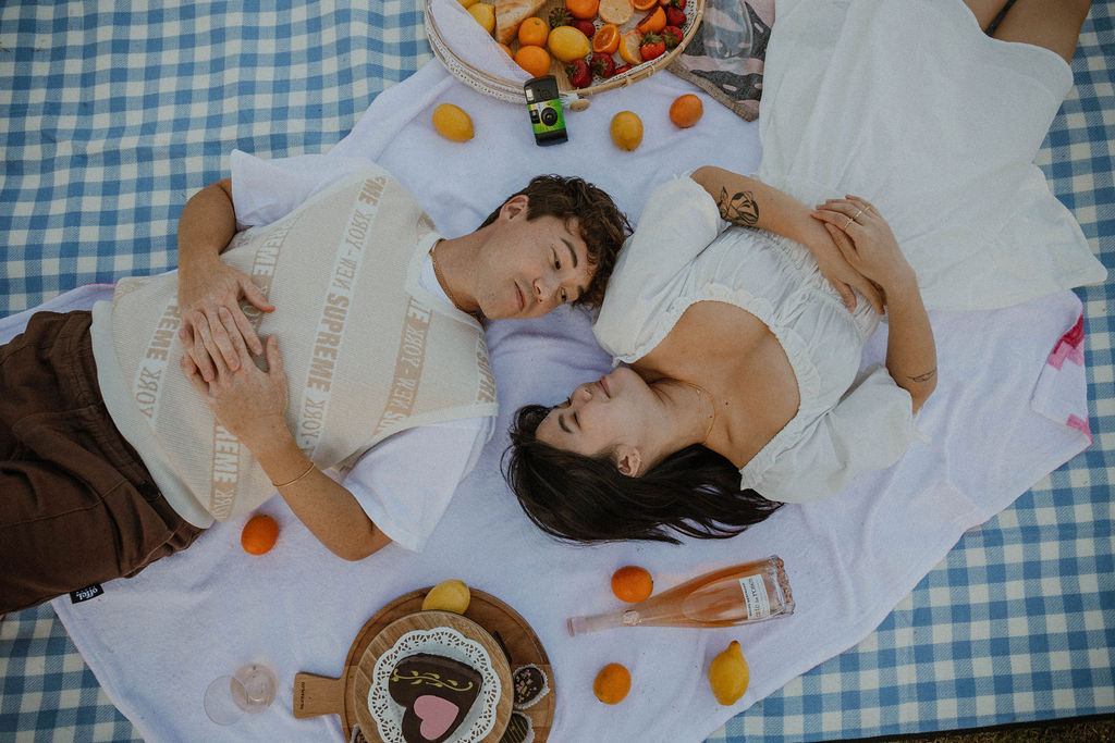 boyfriend and girlfriend laying on their picnic blanket at Manhattan Beach in California
