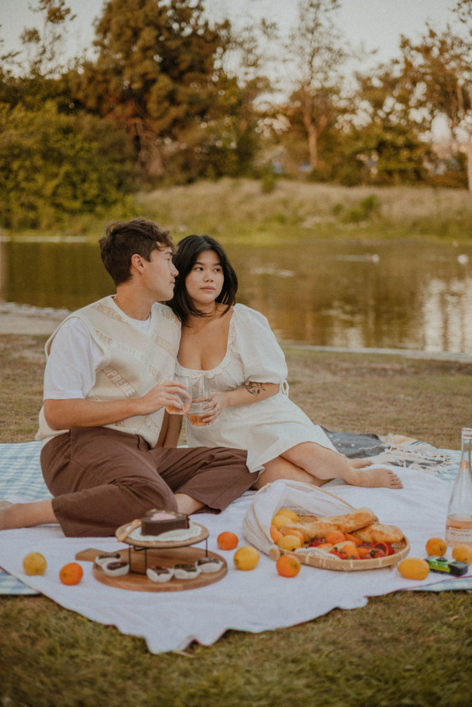 Couple having a picnic and sitting close together on their picnic blanket in California 
