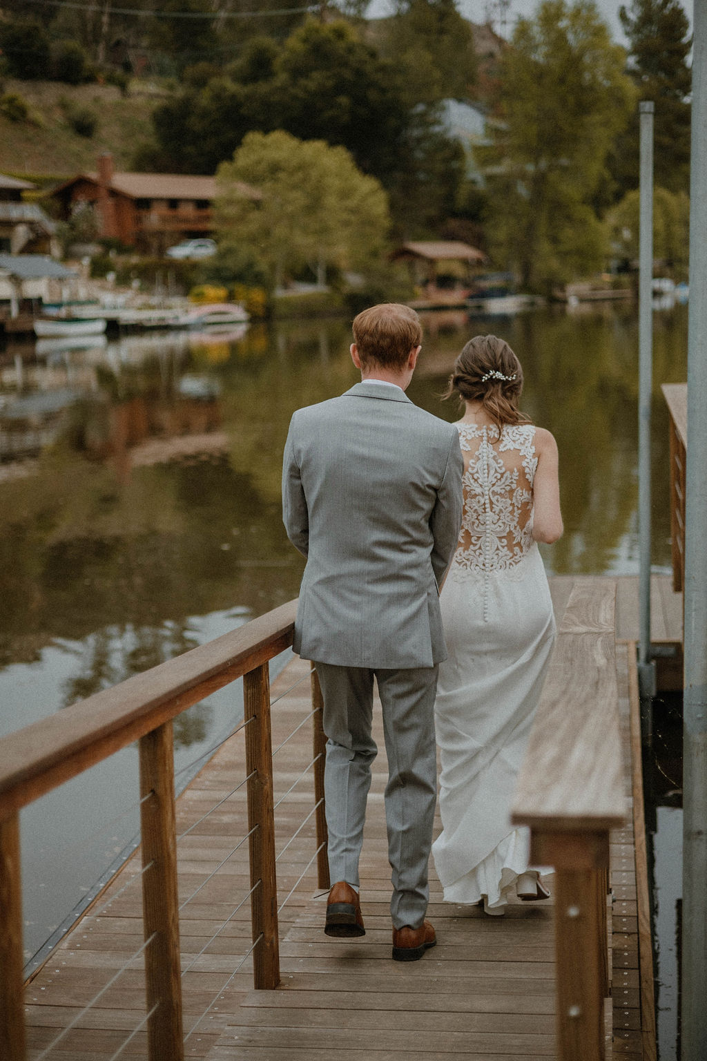 the bride and groom walking down the dock at their California wedding venue