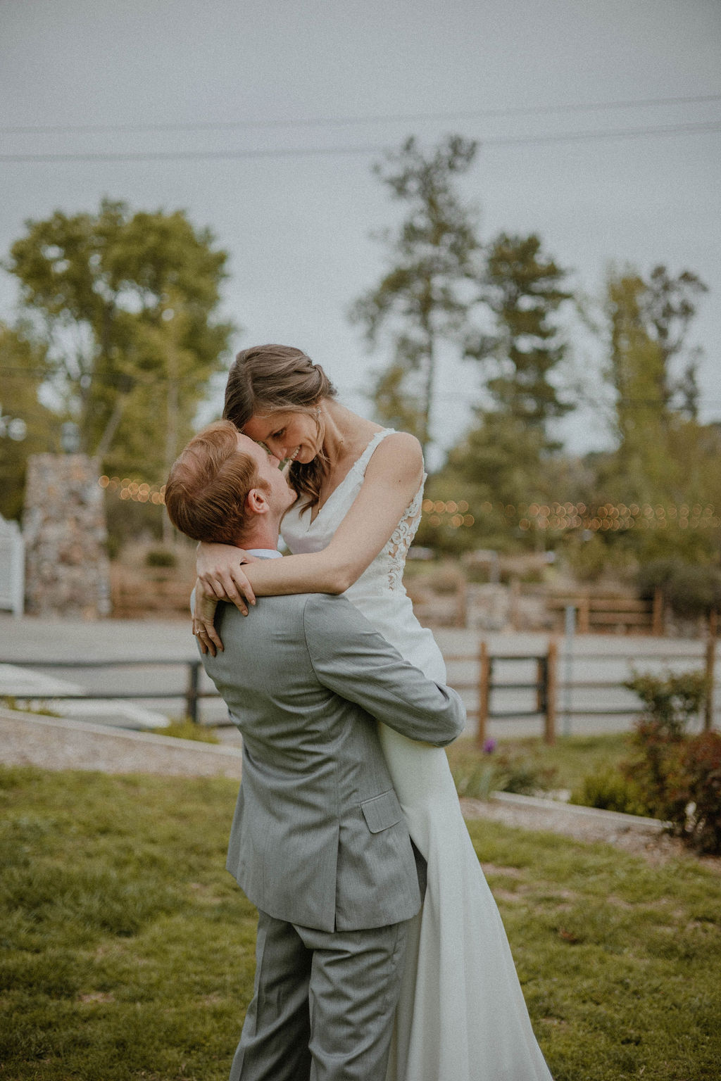 the groom lifts up the bride for a romantic picture at the California wedding venue