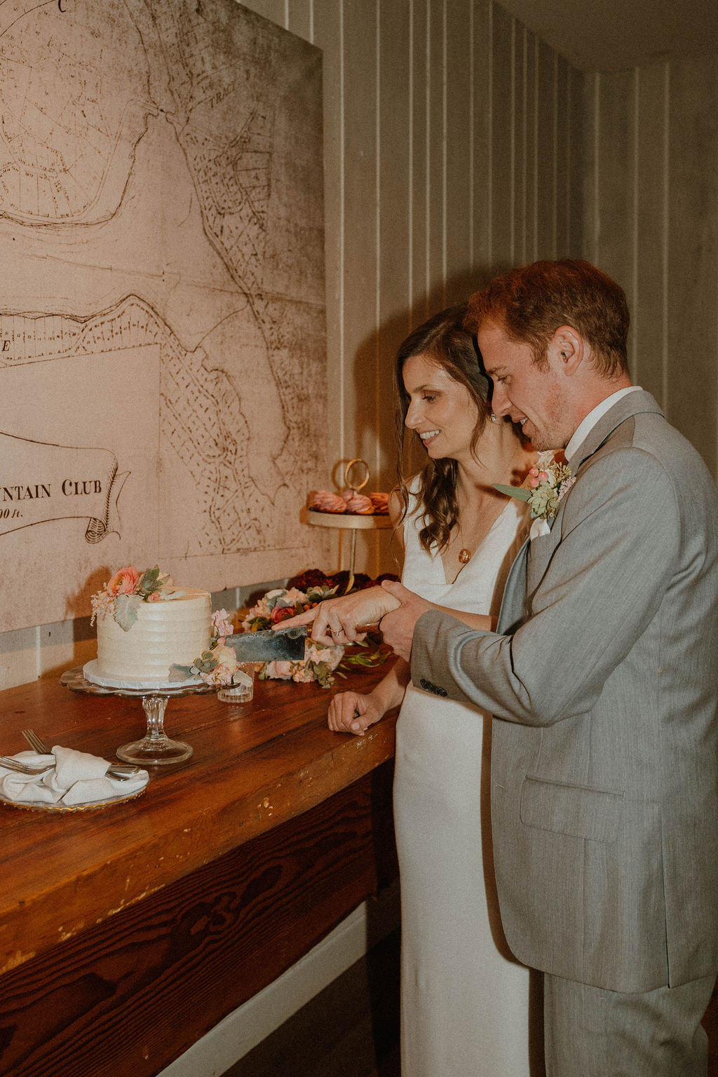 the bride and groom cutting the cake at the California wedding venue