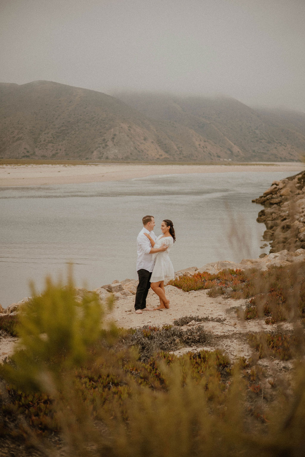 Couple standing out by the water at their Point Mugu Naval Base Engagement Session