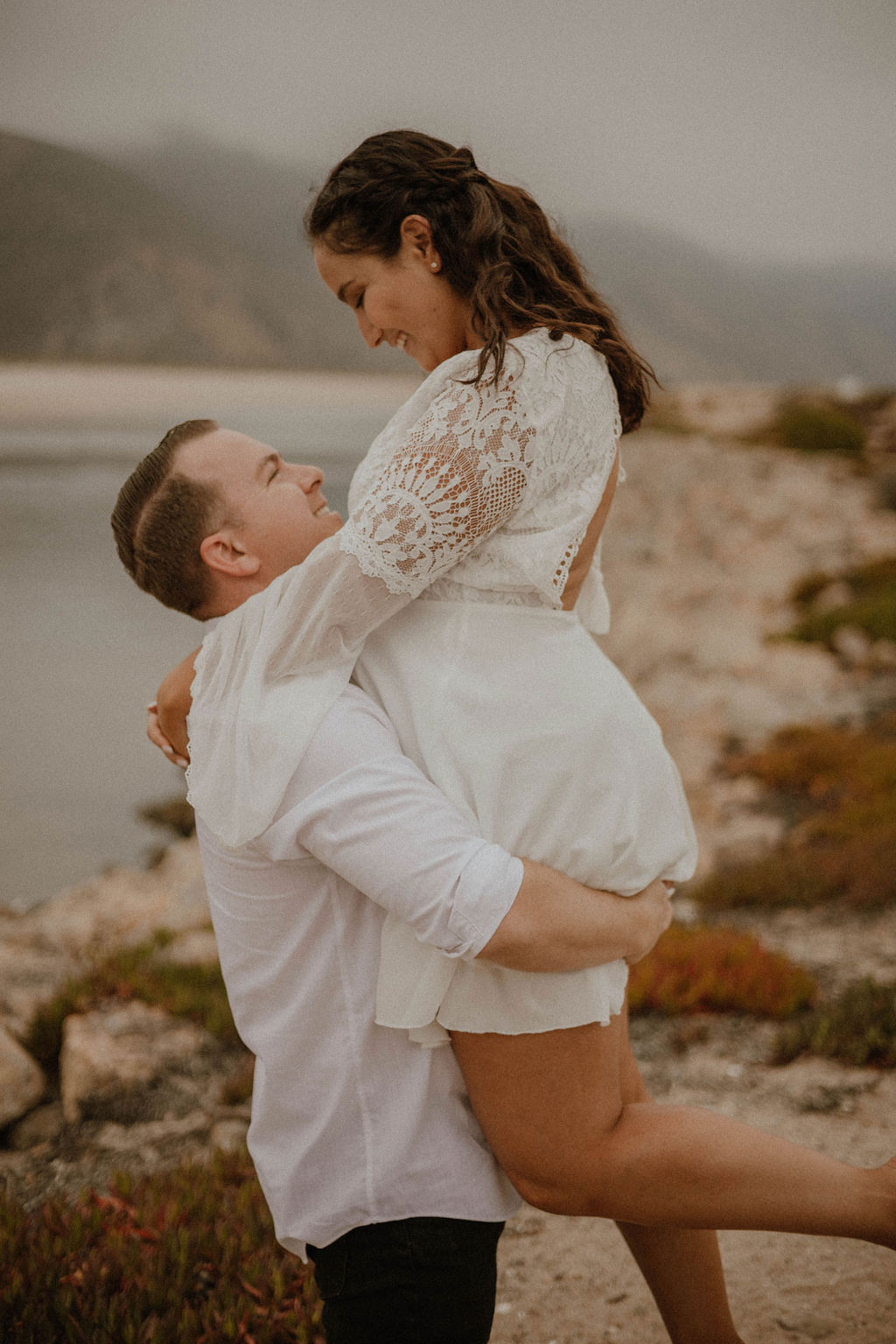 Fiance holding up her up as they gaze into each others eyes for the engagement photographer to capture