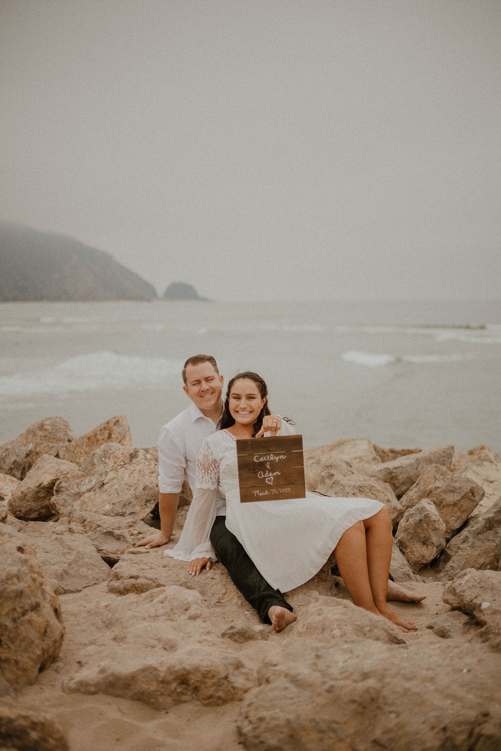 couple with their sign during their engagement photos at Point Mugu Naval Base