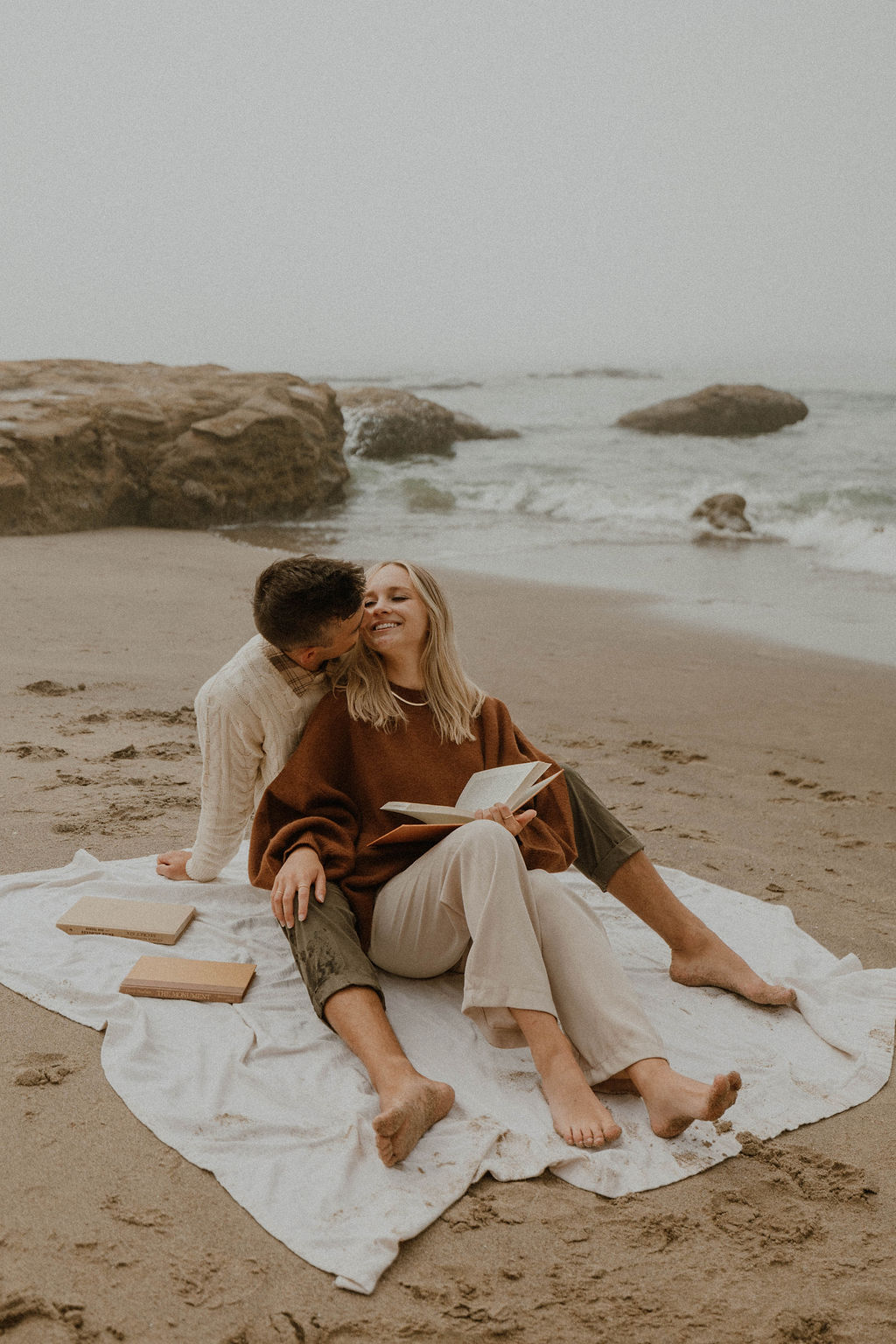 couple reading books together on the beach 