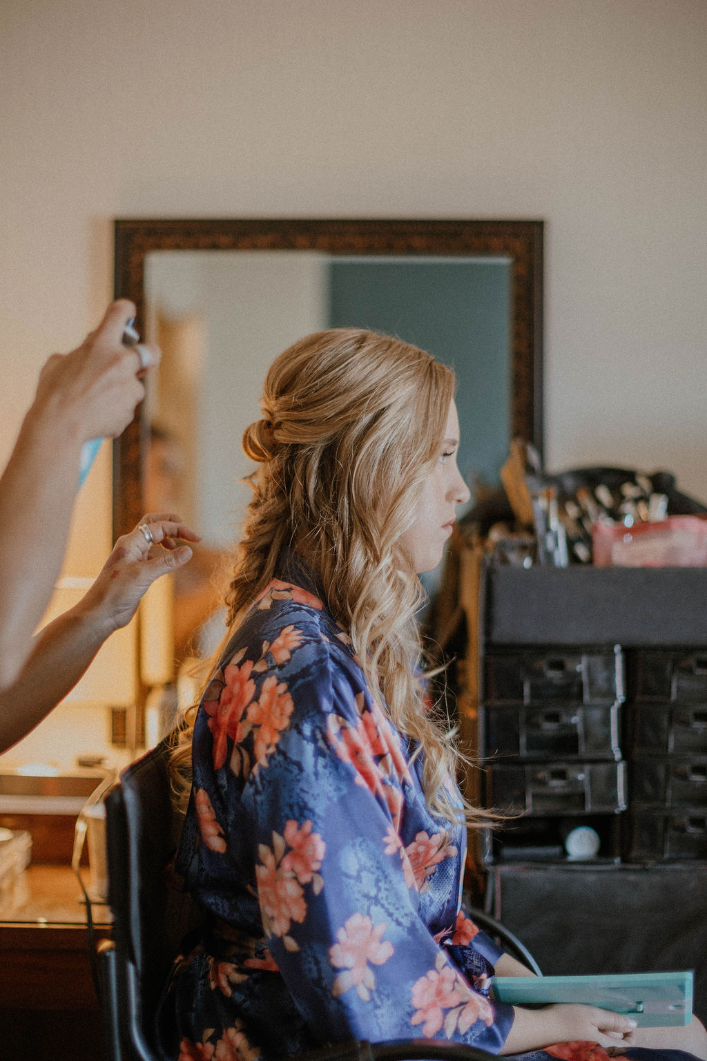the hairdresser spraying the bride's hair