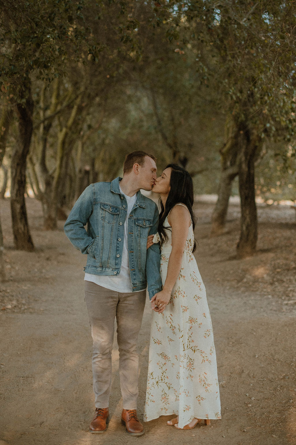 the couple kissing on the trail in front of the couples photographer