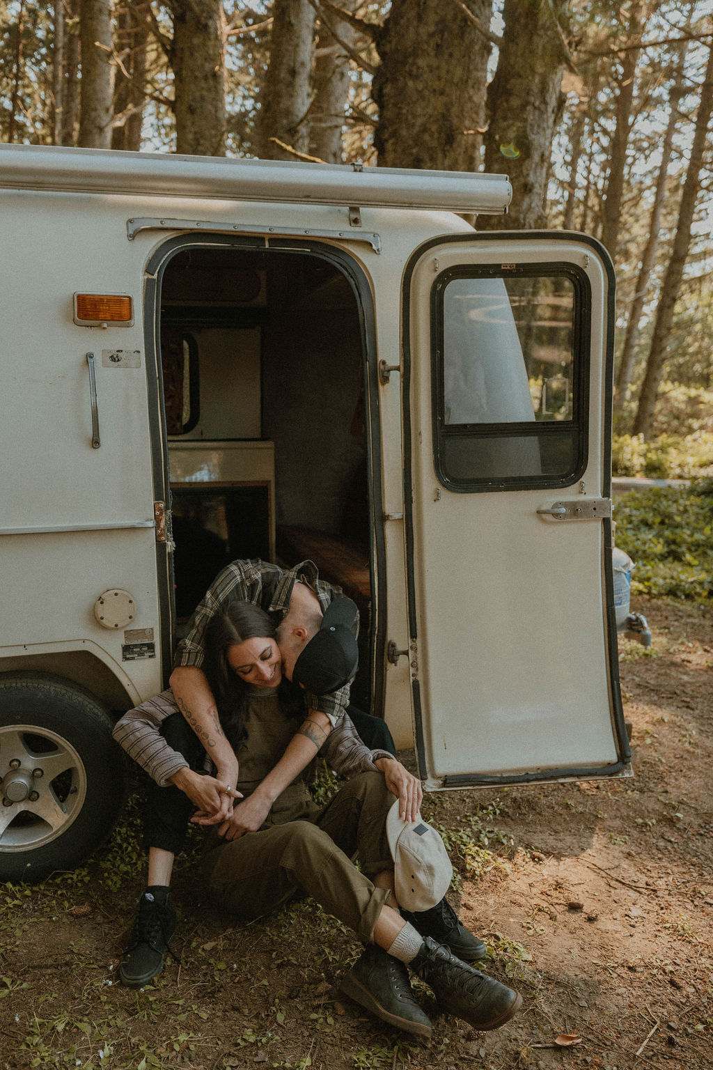 the couple cuddling in the doorway of their camper