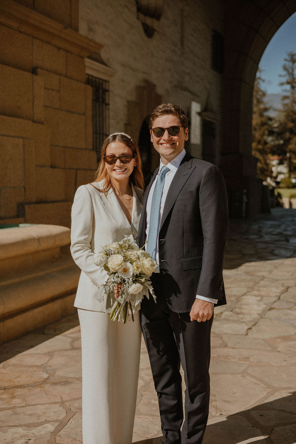 the couple grinning with their sunglasses on