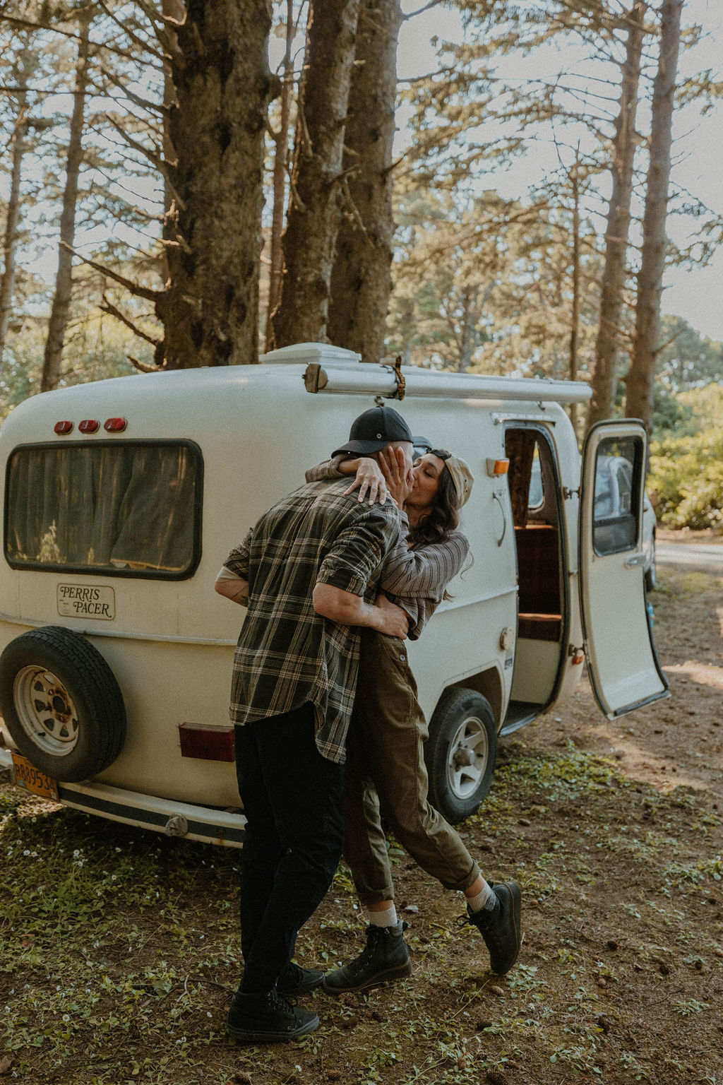 laughing and hugging each other next to their camper